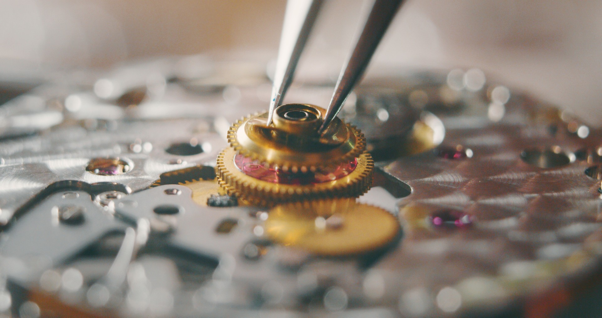 Portrait close up of a professional watchmaker repairer working on a vintage mechanism clock in a workshop.